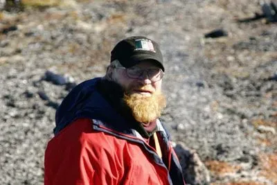 Picture of Markus Dyck standing outside, wearing a red coat and ball cap.